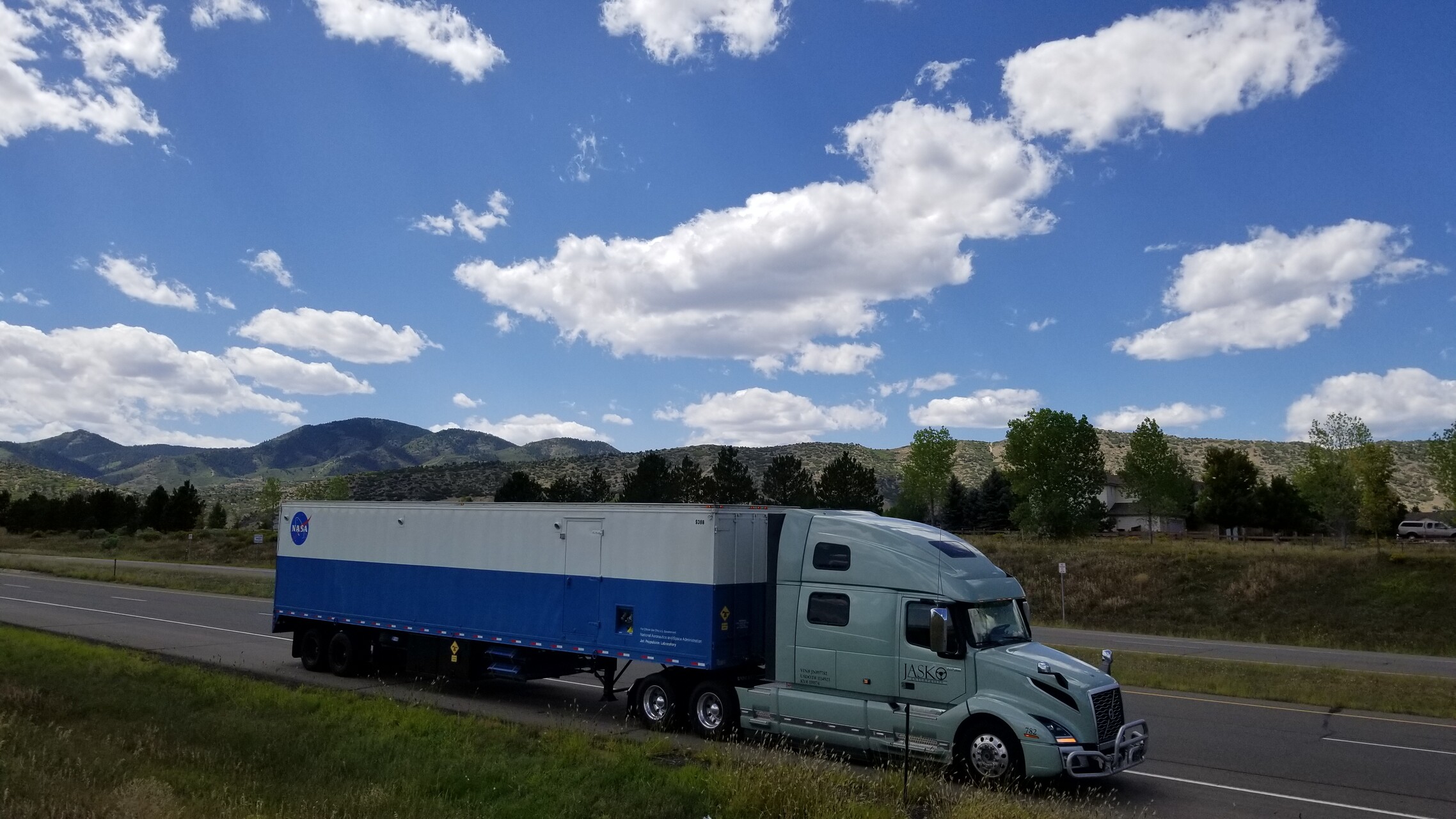 JASKO Volvo tractor hauling an enclosed dry van trailer on a highway