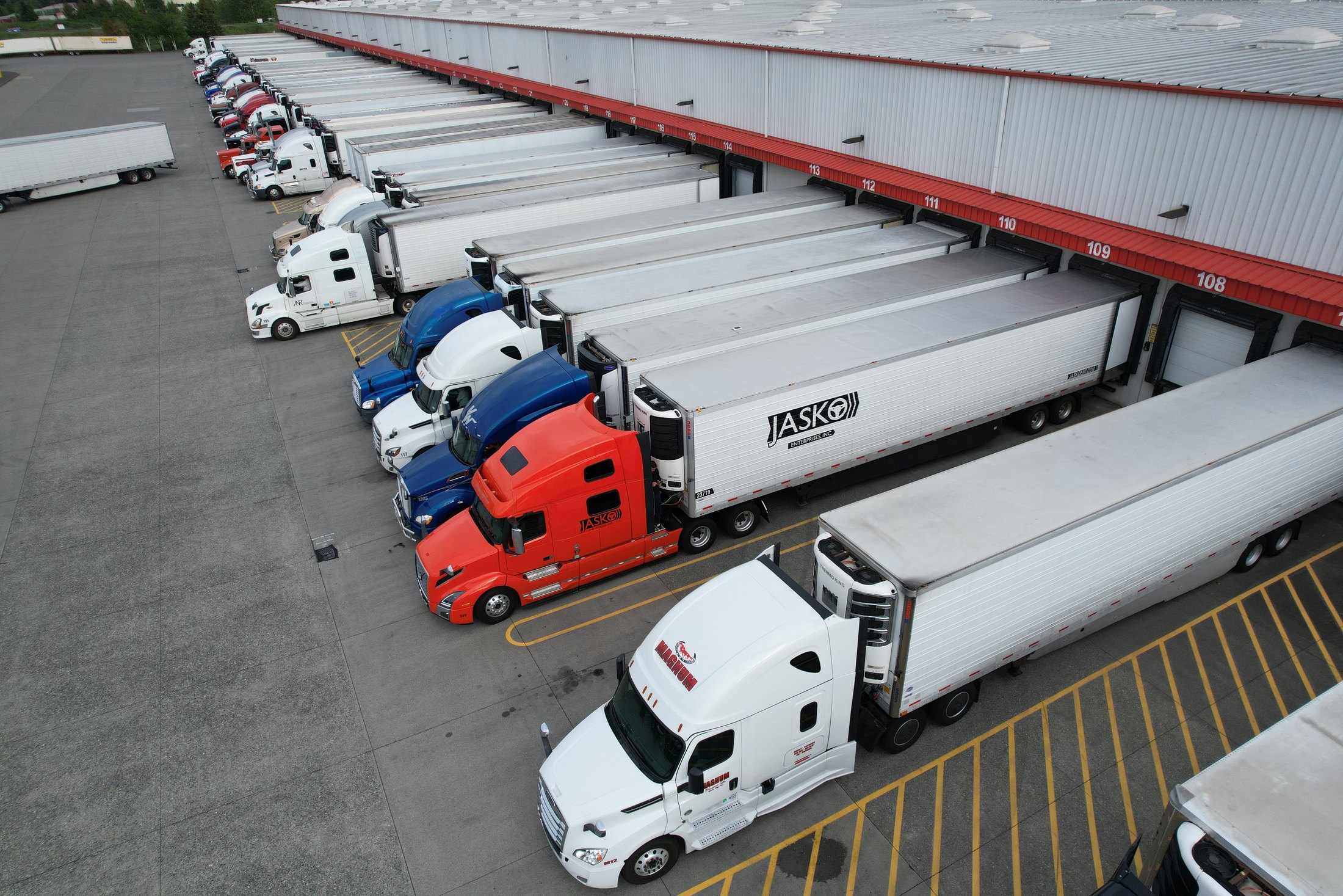 Aerial view of JASKO trucks and refrigerated trailers positioned at loading docks